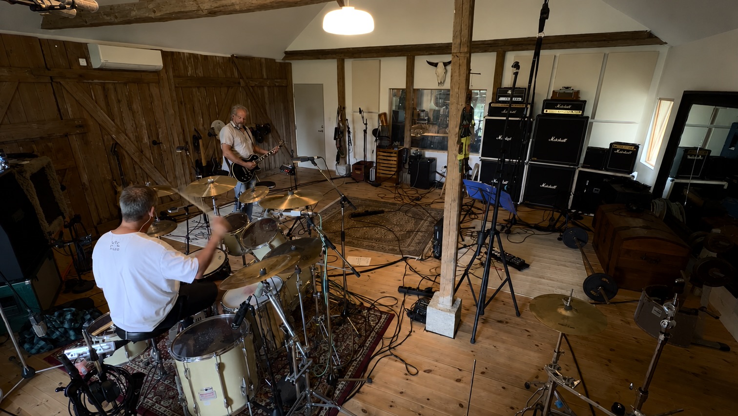 Wide view of the live room with vaulted beams and drum kit